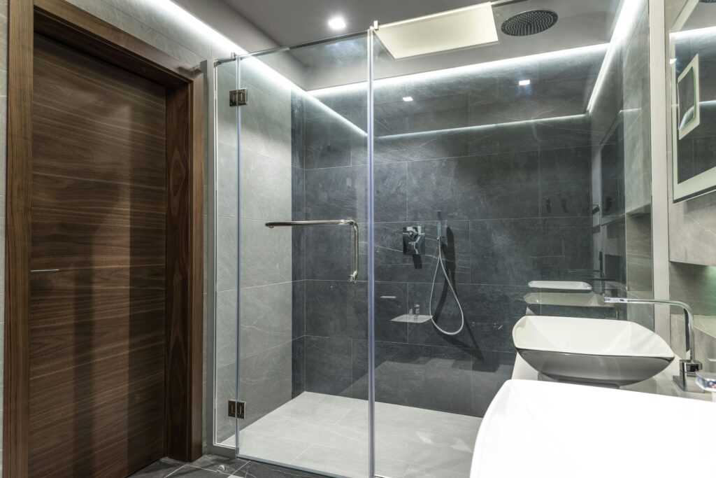 Modern minimalist bathroom featuring a spacious glass shower and sleek interior design.